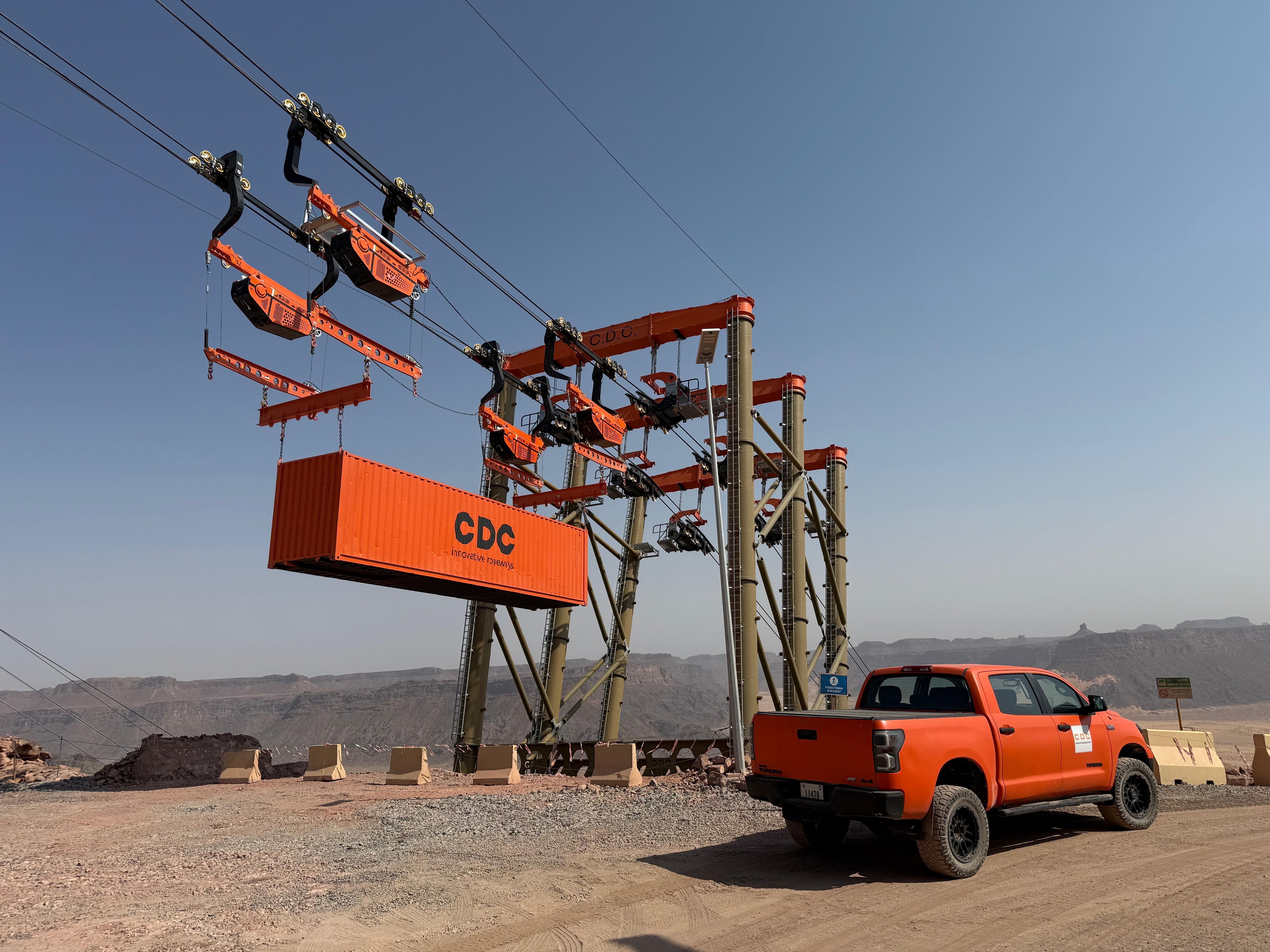 CDC heavy-duty cargo ropeway portal structure with industrial container at desert mining site